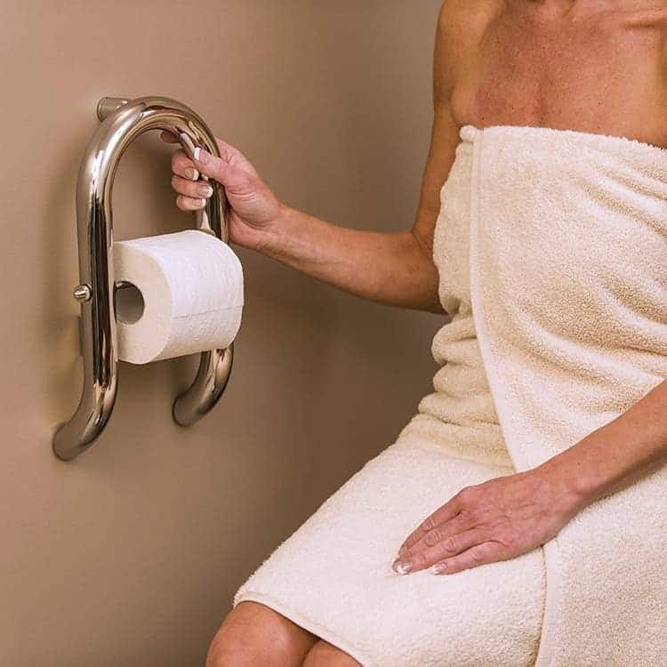 Woman holding the Invisia Toilet Roll Holder for support to stand up from the toilet