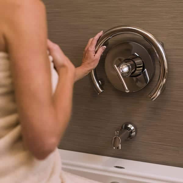 The Invisia Accent ring installed in a shower with a hand using it for support