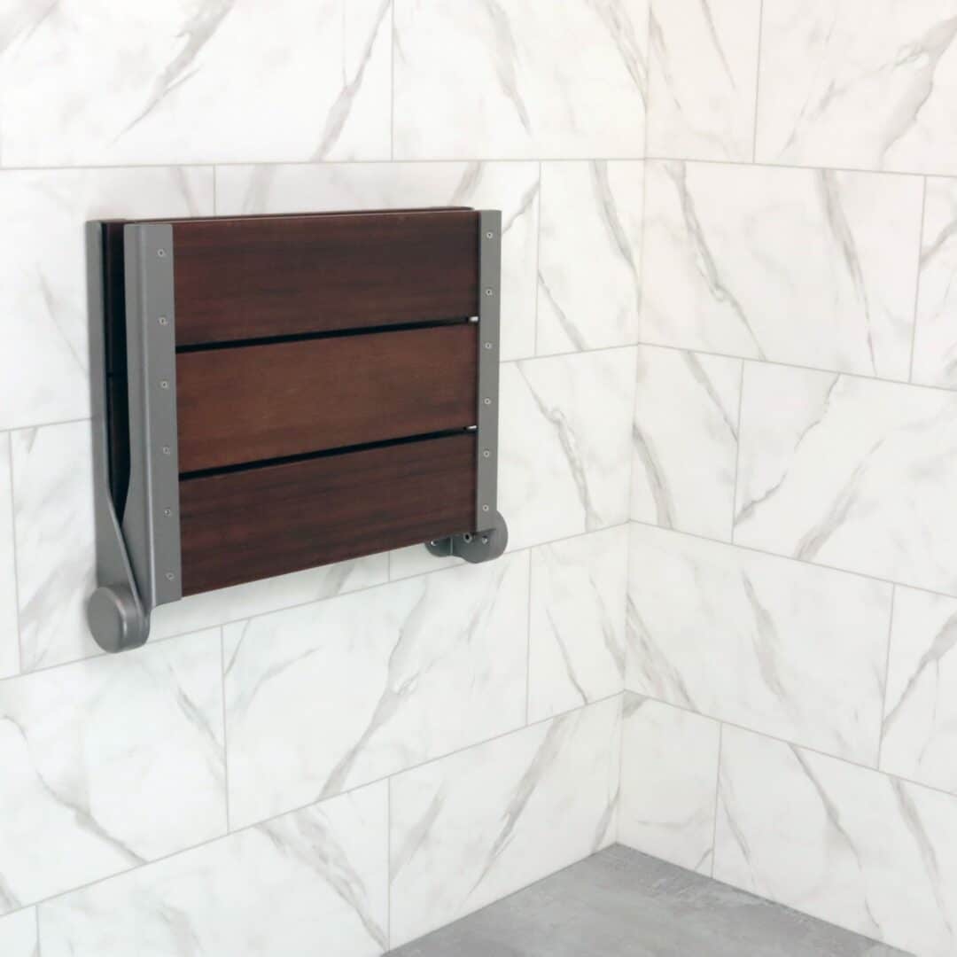 Image of the SerenaSeat installed in a bathroom, folded against the wall to show how compact it is